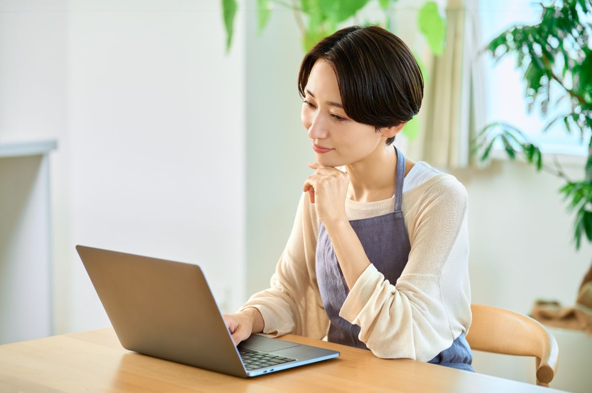 スマホで園児の写真をアップロードする保育士